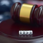 Justice mallet and GDPR acronym close up with US flag on background